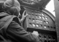 A Flight Engineer seated at his panel inside a Halifax bomber